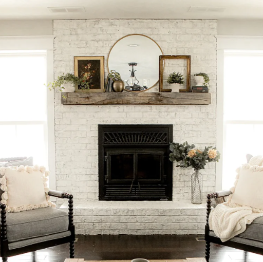 limewashed brick fireplace with mirror and farmhouse decor